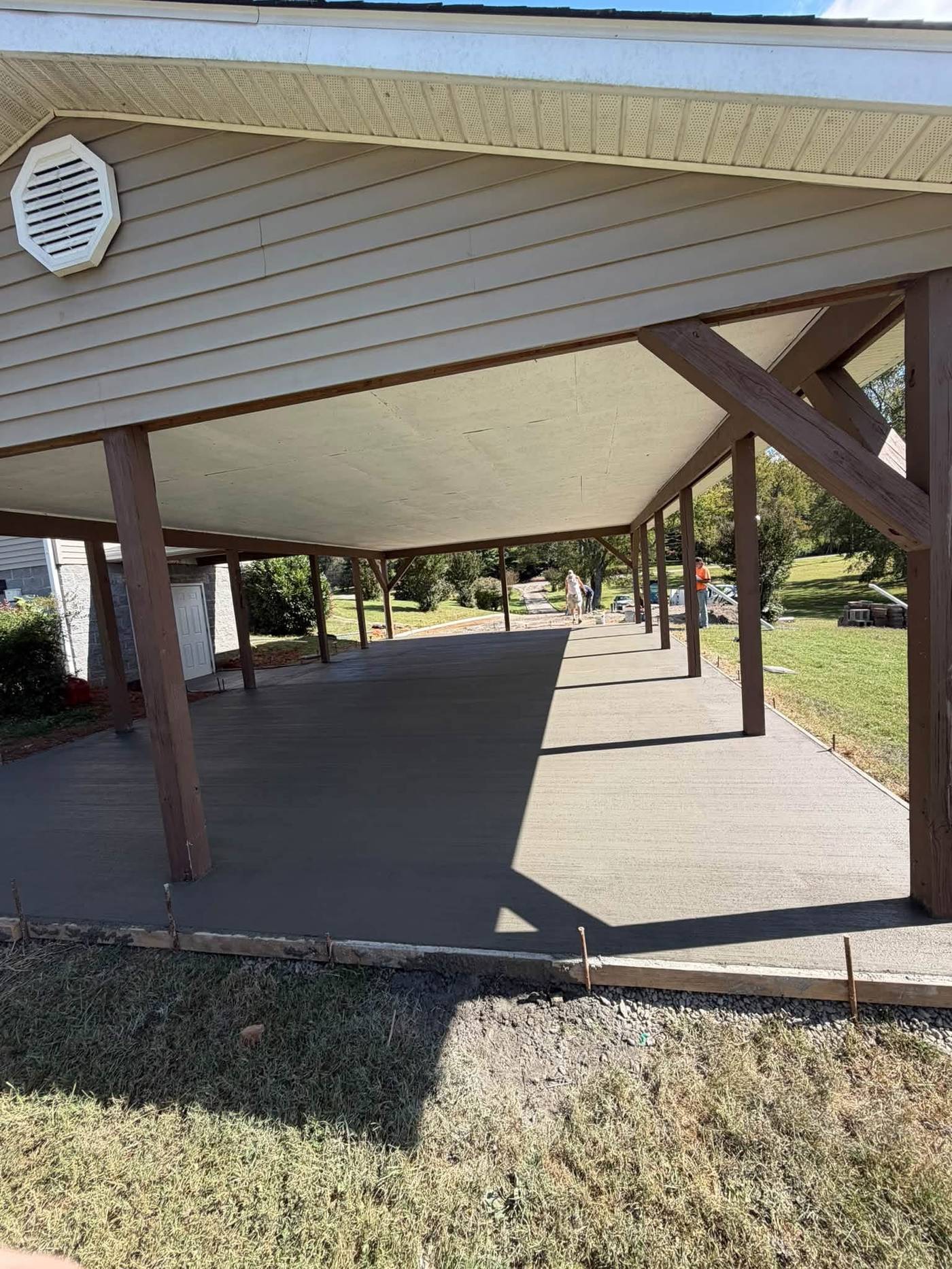 Finished broom-textured concrete slab under a residential carport