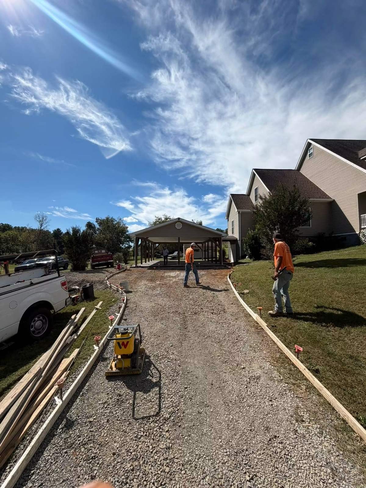 Wooden forms and gravel base set for a driveway and carport concrete pour