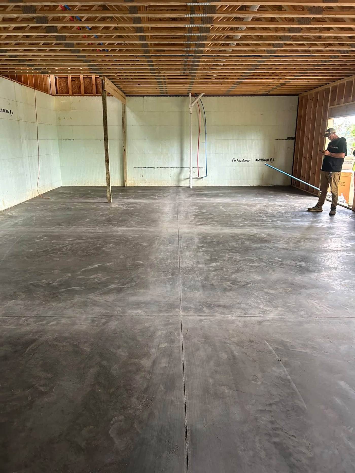 Large finished interior concrete slab inside a framed new construction building
