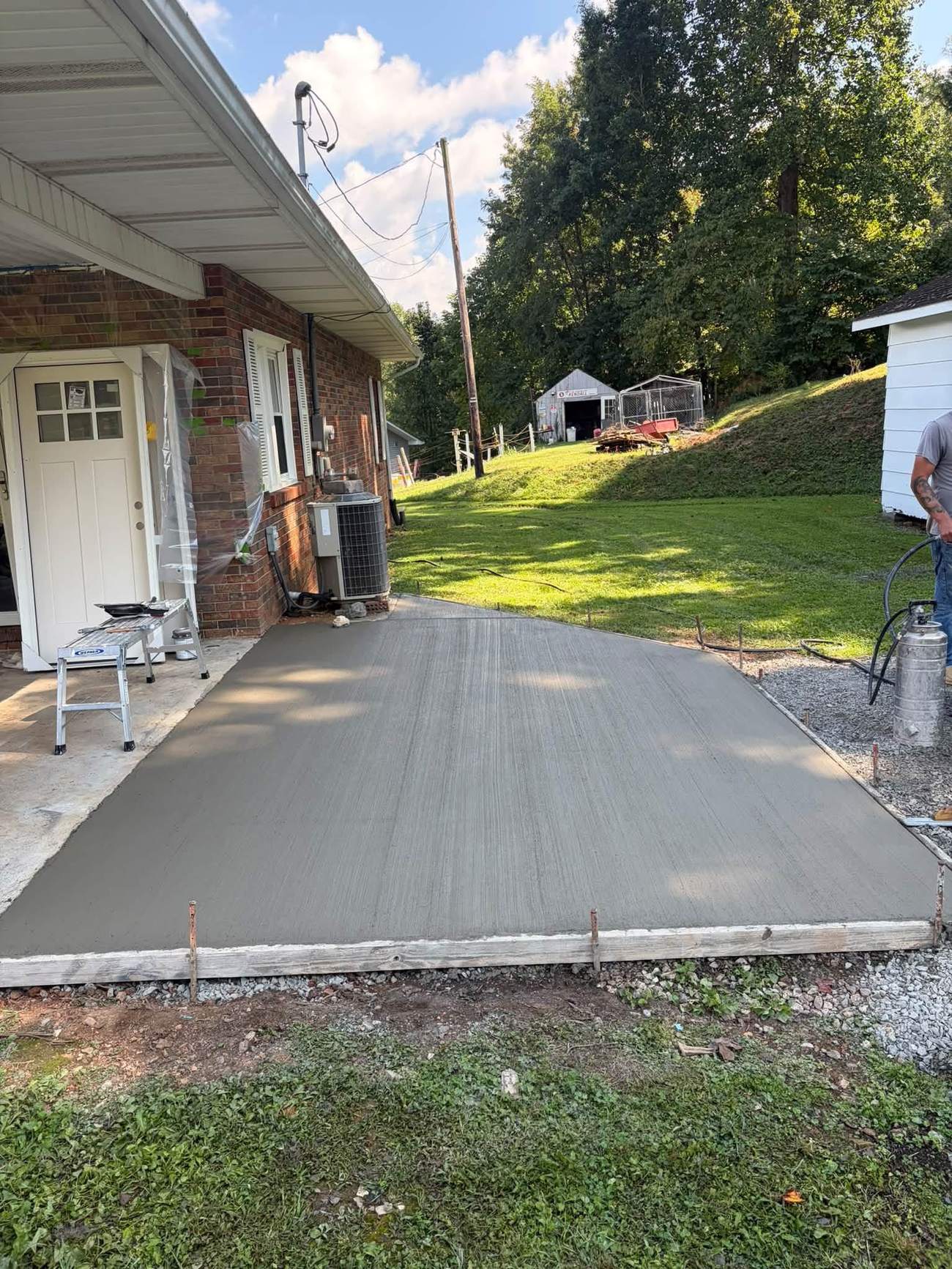 Finished concrete patio slab next to a brick home